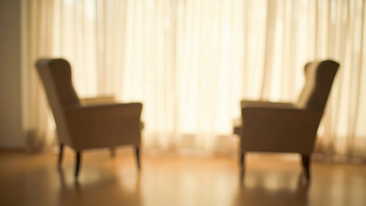 Duas poltronas vazias frente a frente em uma sala clara e silenciosa, com luz natural suave, sem texto na imagem