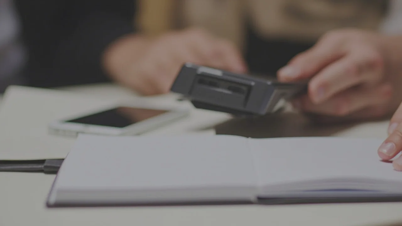 Detalhe próximo de um telefone virado para baixo ao lado de um caderno em branco, contexto calmo de aconselhamento, sem notificações visíveis, sem texto legível, sem logotipos de marca